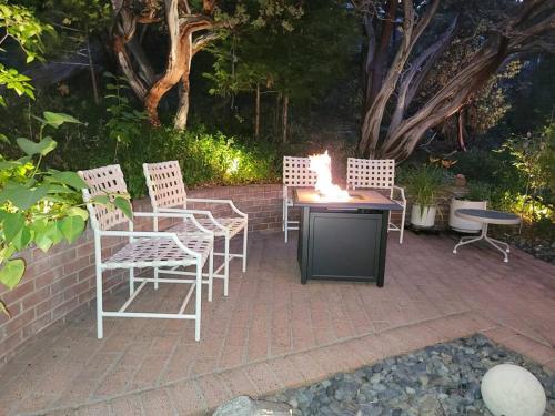 a group of chairs and a table with a fire on it at CASA de los ARBOLES! Delight & Solitude Abound! in Pine Cove