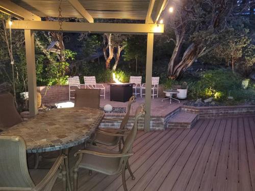 a patio with a table and chairs on a deck at CASA de los ARBOLES! Delight & Solitude Abound! in Pine Cove