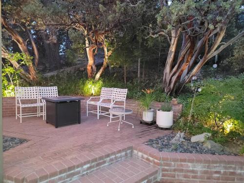 two chairs and a table on a brick patio at CASA de los ARBOLES! Delight & Solitude Abound! in Pine Cove