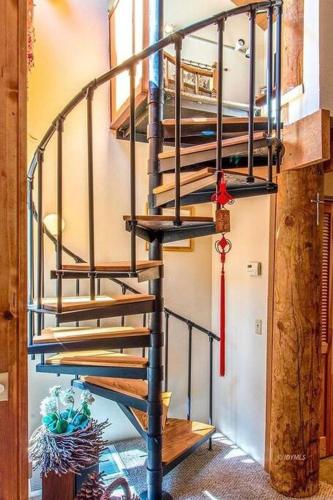 a spiral staircase in a room with a fire extinguisher at CASA de los ARBOLES! Delight & Solitude Abound! in Pine Cove