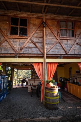a wooden cabin with a red curtain and a barrel at Chalet Ecoturismo La Nohelia in Jericó