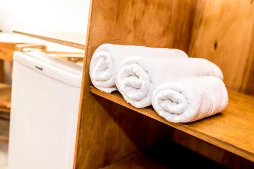 a bunch of towels on a shelf in a bathroom at Vila Juquehy Lofts & Suítes in Juquei