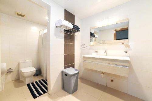 a bathroom with a sink and a toilet and a mirror at Elegante Aqua Marine Apartamento en Playa Juan Dol in Juan Dolio