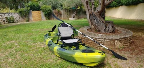 a kayak sitting on the grass next to a tree at Captain Alex Villa 1 in Dafnila