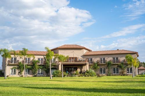 a large house with palm trees in front of it at Sueños Resort in Valle de Guadalupe