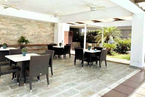 a restaurant with tables and chairs and a patio at Chic and Relax Apartamento Juan Dolio in San Pedro de Macorís