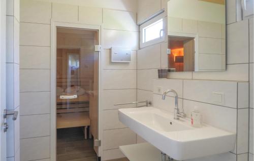 a white bathroom with a sink and a mirror at Ferienhaus 4 Wolfsschlucht in Gondenbrett