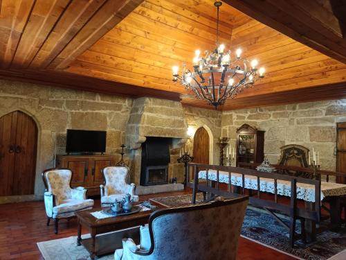 a large living room with a fireplace and a chandelier at Castelo de Portugraal in Vilela