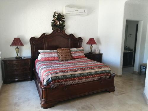 un letto in una camera con due comodini e due lampade di Casa Dahlia a Mazatlán