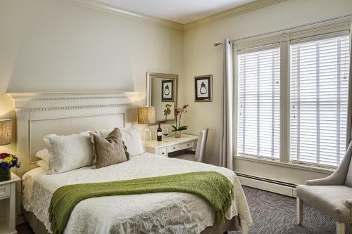 a bedroom with a bed and a chair and a window at Carter House Inns in Eureka