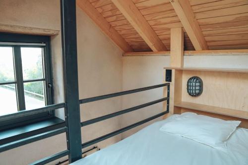 a bed in a room with a window at Den Alen Arbed's Büro in Kayl