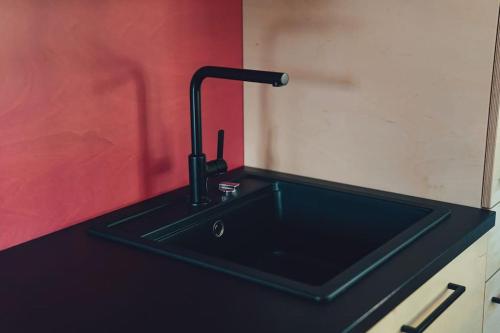 eine schwarze Küchenspüle mit einem schwarzen Wasserhahn in der Unterkunft Den Alen Arbed's Büro in Kayl