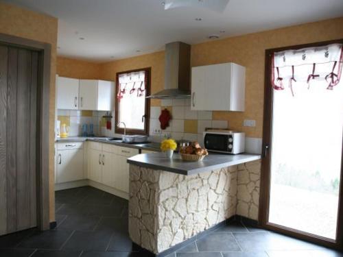 une cuisine avec des armoires blanches et un comptoir dans l'établissement Ferme Vosgienne Rénovée avec Confort et Nature pour 7 Pers, WiFi, Animaux Bienvenus - FR-1-589-190, à Vagney