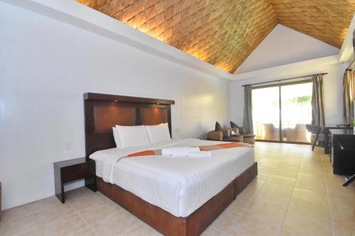 a bedroom with a large bed and a large window at Ambassador In Paradise in Boracay