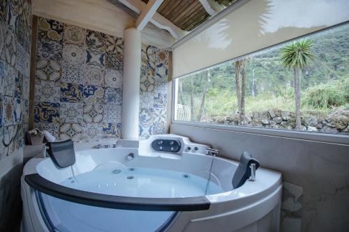 a bathroom with a tub and a window at Rústic Quinta La Aurora in Baños