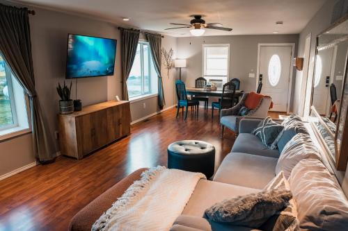 a living room with a couch and a tv at Sandusky Bay Hot Tub, Gym, Patio, Games, Recreation Watercraft, Waterside Home, check it out! in Port Clinton