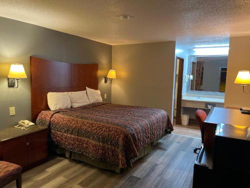 ein Hotelzimmer mit einem Bett und einem Schreibtisch in der Unterkunft Briarwood Inn in Amory