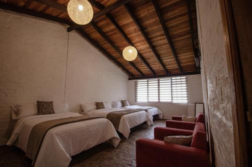 a room with four beds and a window at Rústic Quinta La Aurora in Baños