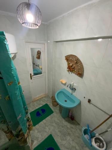 La salle de bains est pourvue d'un lavabo bleu et d'une douche. dans l'établissement Star House City Stars, au Caire