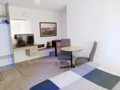 a room with a table and chairs and a kitchen at Cardston Inn in Cardston
