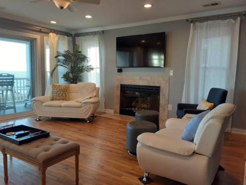 a living room with two couches and a fireplace at Modern 4bdr Oceanfront home in Virginia Beach