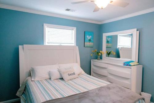 a small bedroom with a bed and a mirror at Modern 4bdr Oceanfront home in Virginia Beach