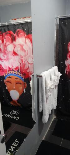 un bagno con asciugamani bianchi e un dipinto di ananas di Tashari-dae Inn king suite a Mandeville
