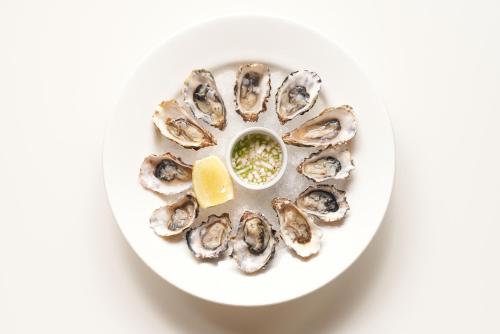 a plate of oysters on a plate with a lemon at The Lodge at Bodega Bay in Bodega Bay