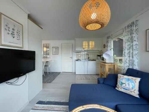 a living room with a blue couch and a kitchen at 4 person holiday home in BENGTSFORS-By Traum in Bengtsfors