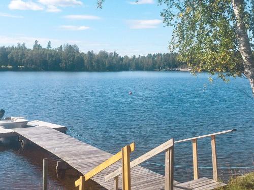 a wooden dock on a large lake with trees at 4 person holiday home in BENGTSFORS-By Traum in Bengtsfors