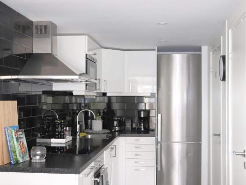 a kitchen with white cabinets and a stainless steel refrigerator at 6 person holiday home in HALMSTAD-By Traum in Halmstad