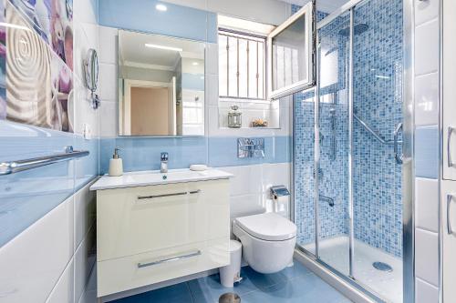 een badkamer met een wastafel, een toilet en een douche bij Bungalow Canarios 1 ,Arguineguín in Mogán