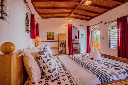 a bedroom with a large bed with red curtains at Atremaru Jungle Retreat in Puerto Princesa City