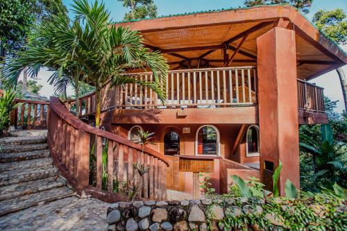 Casa con terraza de madera y escaleras en Atremaru Jungle Retreat en Puerto Princesa