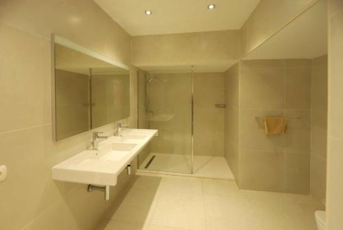 プエルト・デル・カルメンにあるCancillaのバスルーム(洗面台2台、ガラス張りのシャワー付)