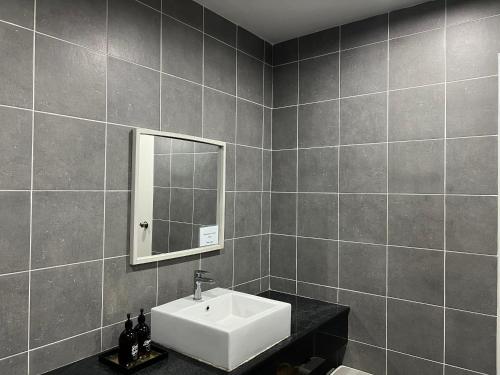 uma casa de banho com um lavatório e um espelho em 4 bedrooms (private bathroom) Perdana Hill Villa em Lahad Datu