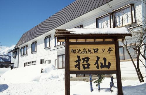a sign in the snow in front of a building at Lodge Shosen in Otari