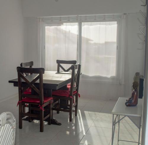 a table and chairs in a room with a window at BAHÍA NORTE.Tres ambientes con cochera a metros del mar in Mar del Plata