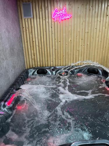 a jacuzzi tub with a woman bathing in it at Penthouse Style Luxury 2 Bedroom House has Hot-Tub, extra fees apply in Birmingham