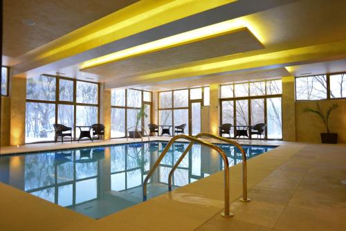 a swimming pool in a building with windows at Bucium Motel & SPA in Iaşi