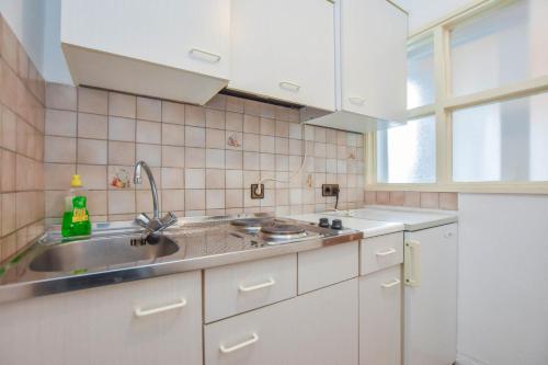 a kitchen with white cabinets and a sink at Apartments Promina in Biograd na Moru