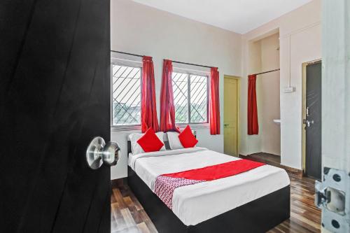 Schlafzimmer mit einem Bett mit roten Vorhängen in der Unterkunft OYO Shree Balaji Lodging in Chikalthān