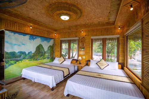 two beds in a room with a painting on the wall at Xuan Son Lakeside Bungalow in Ninh Binh