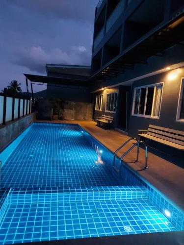 a swimming pool in a building at night at AM Surin Place - SHA Extra Plus in Surin Beach