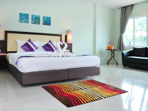 - une chambre avec un grand lit et un canapé dans l'établissement AM Surin Place - SHA Extra Plus, à Surin Beach