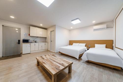 um quarto com duas camas e uma mesa em Seorak HOT Spring Mammoth Resotel em Sokcho