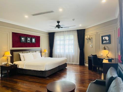 une chambre d'hôtel avec un lit et un canapé dans l'établissement Hotel du Monde, à Hanoï