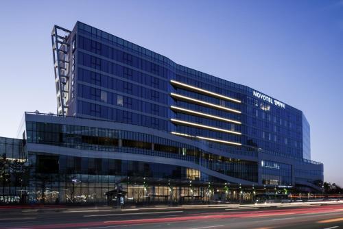 a large glass building with a street in front of it at Novotel Ambassador Suwon in Suwon