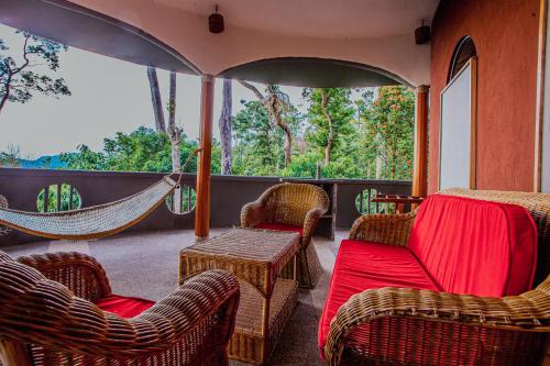 a room with chairs and hammocks on a porch at Atremaru Jungle Retreat in Puerto Princesa City