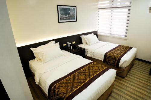 een hotelkamer met 2 bedden en een raam bij PRIMELUXE HOTEL in Cagayan de Oro